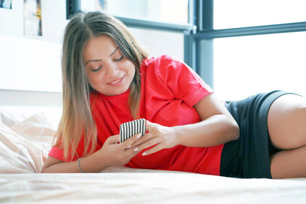 istock Girl in bed with a smartphone 1071053366