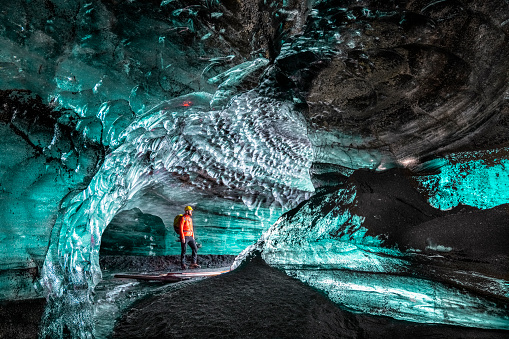 Hiker standing in ice cave. Full length of male on a glacier in Ice cave. Idyllic crystals at Iceland.
