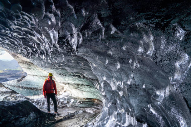 istock Hiker standing in ice cave at Iceland glacier 1071053682
