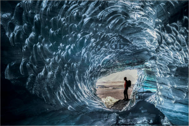 istock Hiker seen through glacier tunnel at Iceland 1071053684
