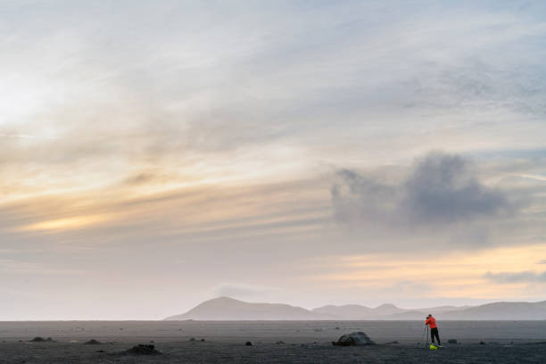 istock Photographer on volcanic landscape during sunset 1071055248