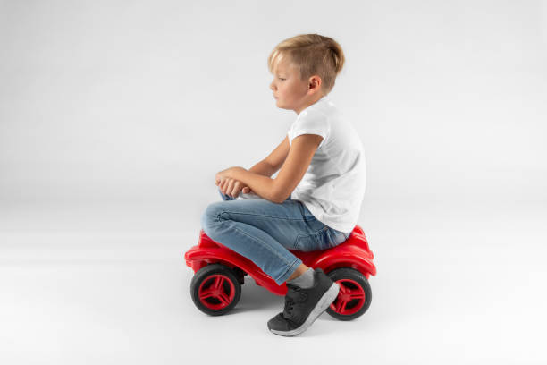 istock little blond boy is sitting on a toy vehicle 1071056514