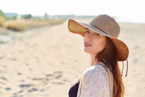 istock Beautiful young woman in straw hat on the beach 1071057066