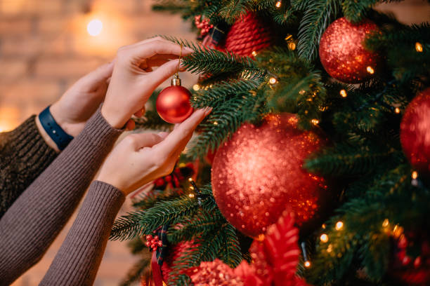 istock young husband and wife decorate Christmas tree together 1071059676