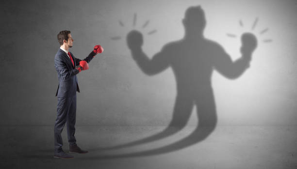istock Businessman fighting with his unarmed shadow 1071068640