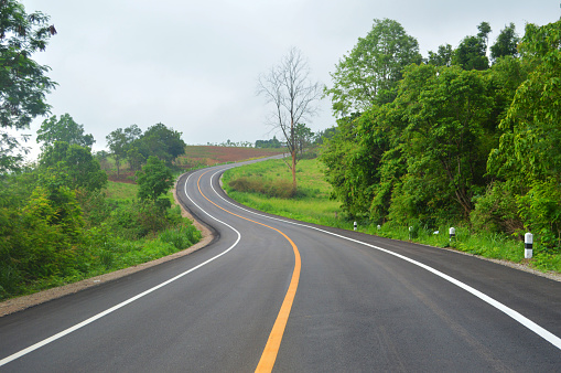 curve road driving / asphalt of road for car travel transportation on mountain - countryside road curve with line to the mountains green tree forest on roadside
