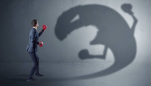 istock Businessman fighting with a big monster shadow 1071069120