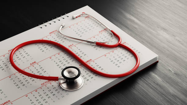 red stethoscope and a calendar on black wood surface - appointment reminder doctor calendar imagens e fotografias de stock