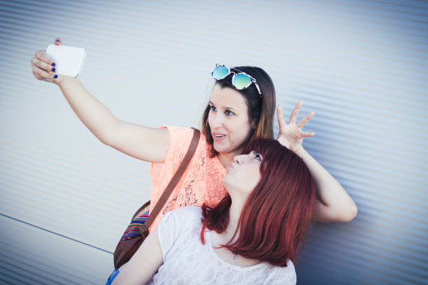 istock two best friends girls having fun and  making selfie 1071072954