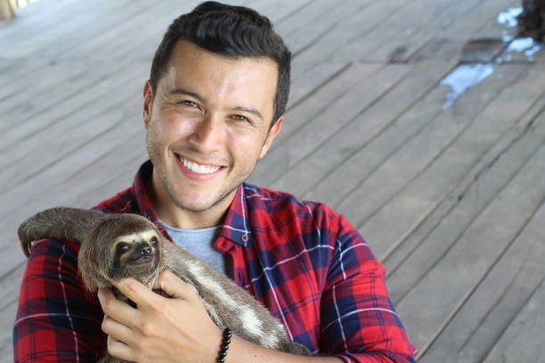 istock Tender ethnic man taking care of a sloth bear 1071078570