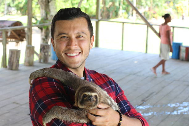 istock Tender ethnic man taking care of a sloth bear 1071078572