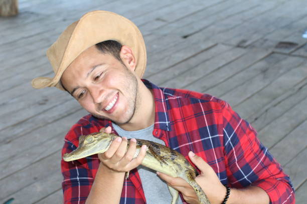 istock Ethnic man holding baby caiman 1071078666