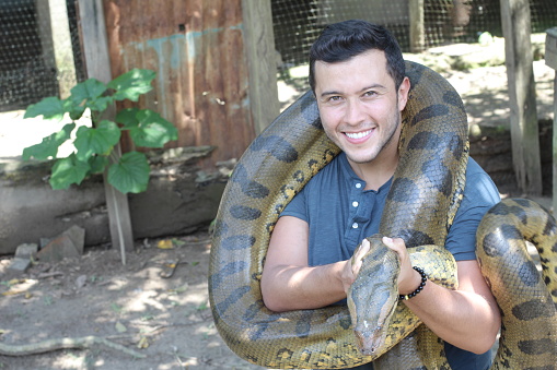 Man with a giant Anaconda around his neck.