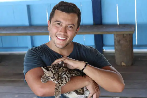 Photo of Man holding baby wild feline
