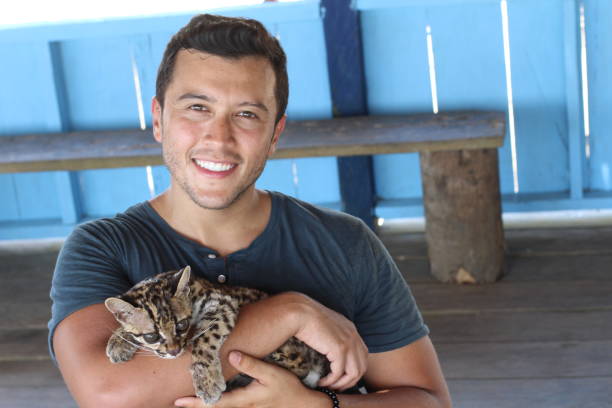 istock Handsome ethnic man holding a baby ocelot 1071079220