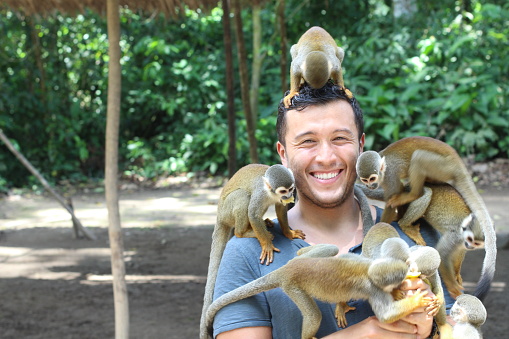 Handsome ethnic man with titi monkeys.