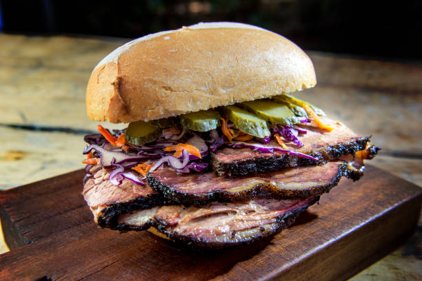 Brisket Sandwich with cucumber and coleslaw on cutting board Detail of Brisket Sandwich with cucumber and coleslow on wooden cutting boardBrisket Sandwich with cucumber and coleslaw on wooden cutting board brisket photos stock pictures, royalty-free photos & images