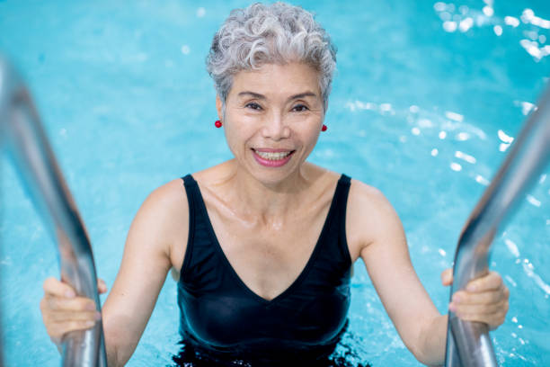 istock Senior woman getting in the pool 1071085644
