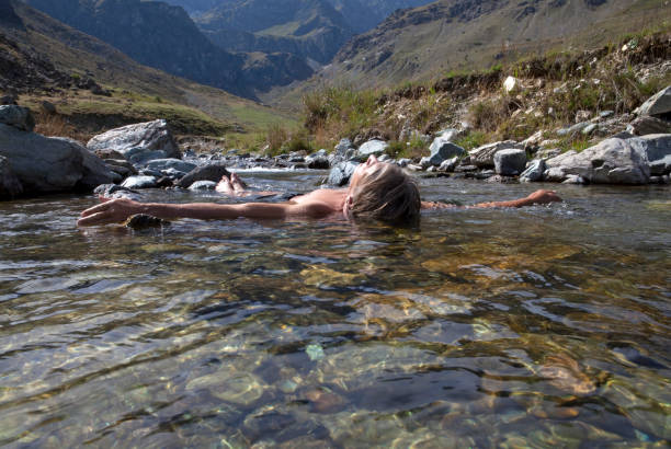istock Man floats on back in mountain stream 1071089828