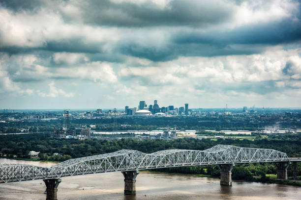 Distant Skyline of New Orleans A bridge spanning the mighty Mississippi River in southern Louisiana with the skyline of New Orleans in the background. louisiana photos stock pictures, royalty-free photos & images