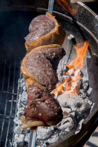 istock Picanha skewer cooks on the coals and flames 1071092800