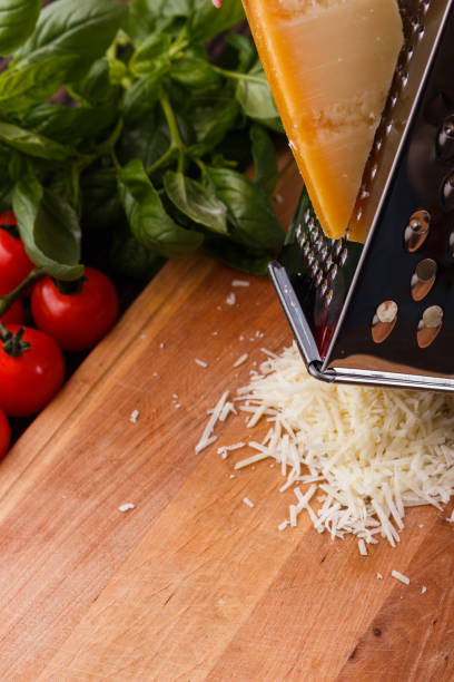 young woman grater Parmesan cheese on a wooden board