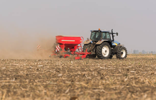 istock Farmer with tractor seeding  crops at agricultural field 1071096686