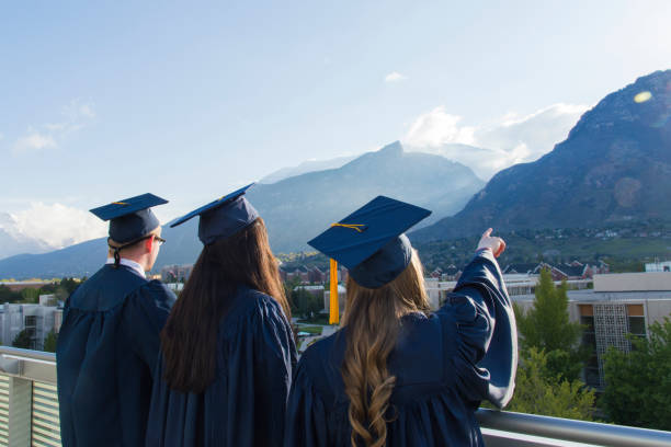 The Thrill of Graduating - Students at Brigham Young University Graduation ceremonies have been held over the past two days at the BYU campus.  I took a few shots of students, illustrating the excitement of graduation.  This one was taken on the viewing deck of the JFSB right as the sun was clearing Y Mountain. brigham young university stock pictures, royalty-free photos & images
