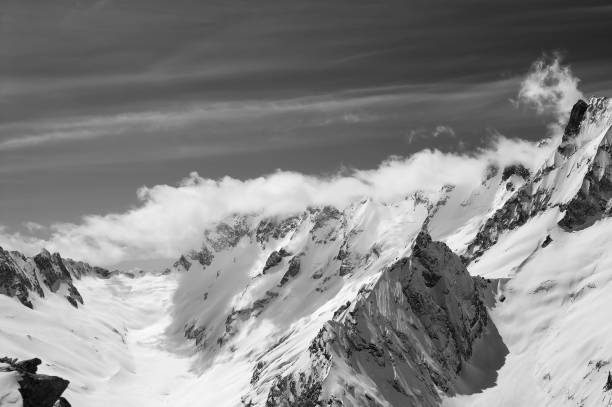 istock Black and white snowy mountains in clouds at sun wind day 1071100288
