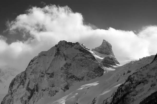 istock High mountains in snow and sunlight sky with clouds at cold winter evening 1071100296