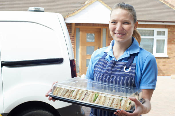 Female Caterer Delivering Tray Of Sandwiches To House Female Caterer Delivering Tray Of Sandwiches To House caterer photos stock pictures, royalty-free photos & images