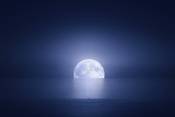 big moon over the sea at night stock photo