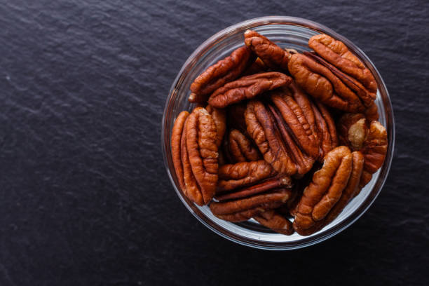 istock delicious pecan nuts on a dark stone background 1071110394