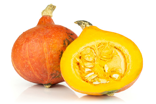 Group of one whole one half of fresh red kuri pumpkin hokkaido variety fresh cut section with seeds isolated on white background