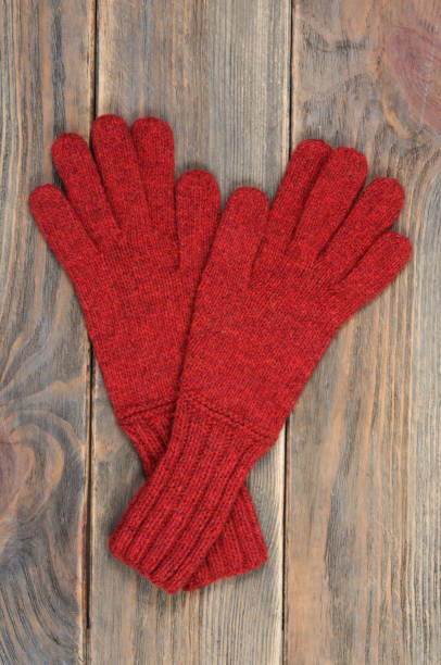 istock Red gloves on a wooden background. 1071113204