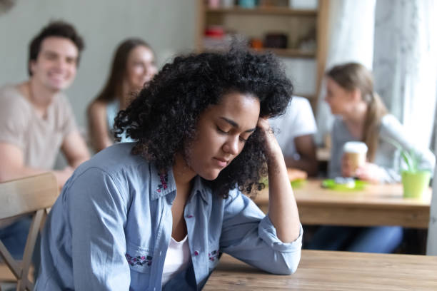 istock Mixed race girl sitting alone separately from other mates 1071116572