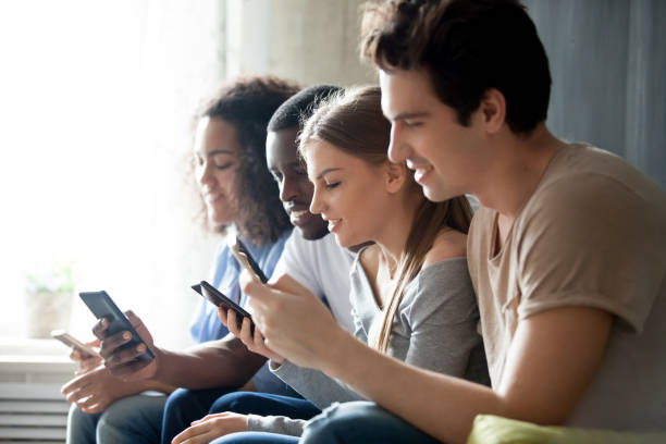 istock Diverse people sitting together using mobile phones 1071117716