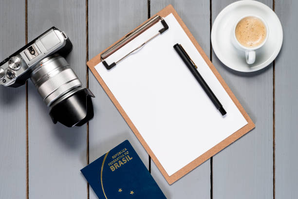 istock Camera and notepad on wooden background. Brazilian passport. 1071118366