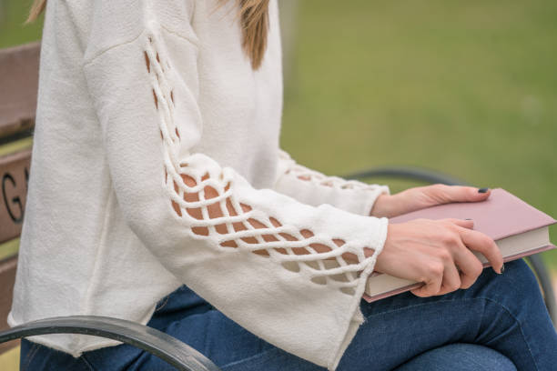 istock beautiful woman reading book on bench 1071118542