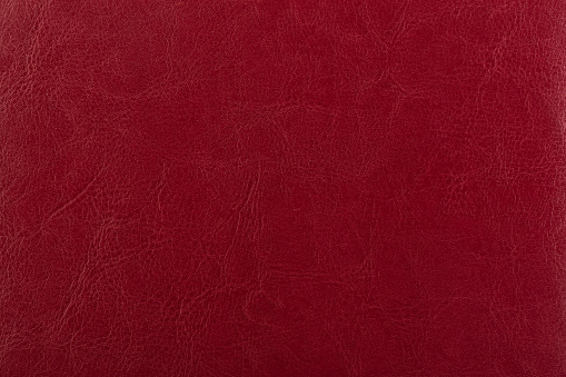 Dark red leather surface as a background, leather texture. Skin texture concept. Copy space. Close up