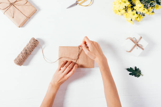 istock Flat lay arrangement female's hands tying bow on gift box 1071129584