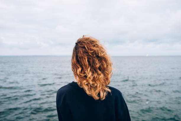 istock Female with red curly hair outdoors standing 1071129592
