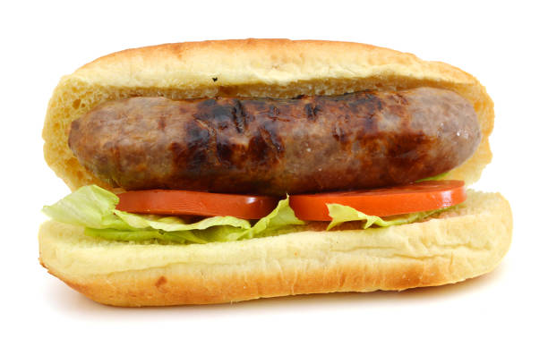istock Grilled bratwurst on a bun and tomato, salad on white 1071141802