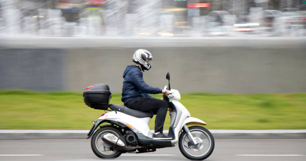 One young man riding scooter with rear storage box stock photo