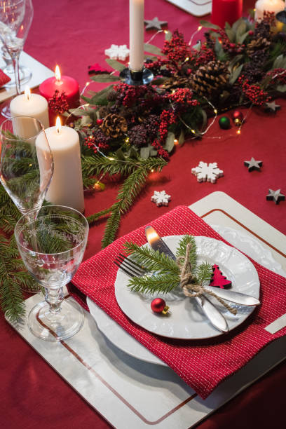 istock Table served for Christmas dinner, festive setting with decorations, burning candles and fir-tree branches 1071142806