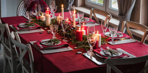 istock Table served for Christmas dinner, festive setting with decorations, burning candles and fir-tree branches 1071142820