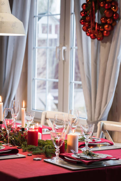 istock Table served for Christmas dinner, festive setting with decorations, burning candles and fir-tree branches 1071142924