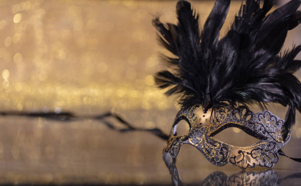 istock Carnival mask with feathers on golden bokeh background 1071149048