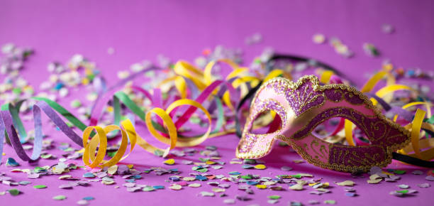 istock Carnival mask, streamers and confetti on purple background 1071149068