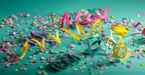 Carnival or birthday party. Confetti and serpentines on bright green background
